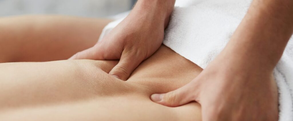 Therapist giving thigh massage to client